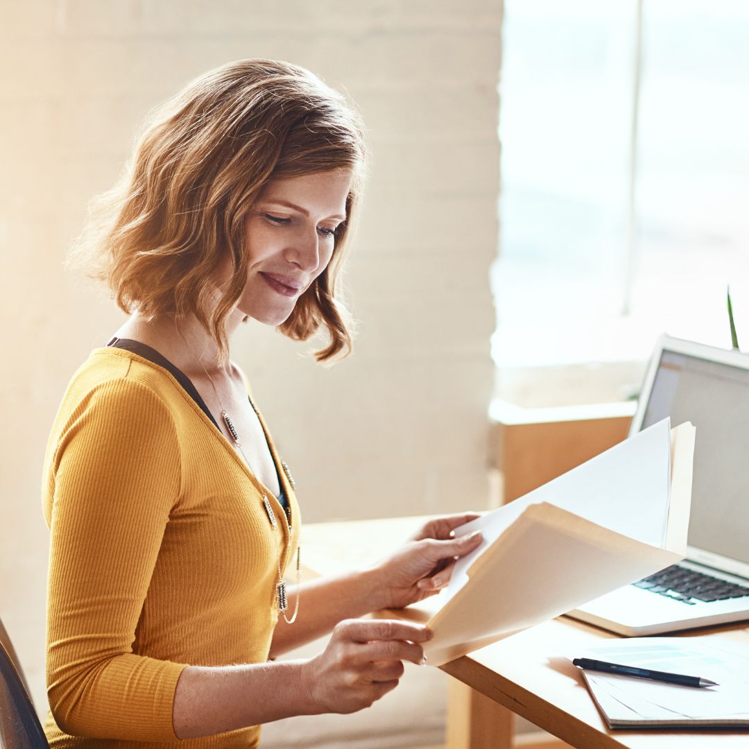 Woman looking through documents in a folder. 