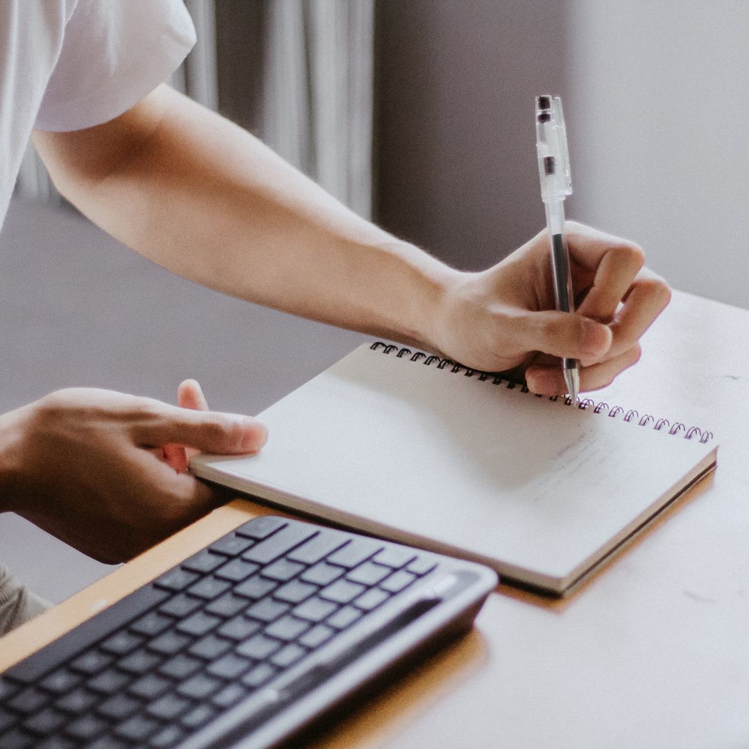 Taking notes next to a computer