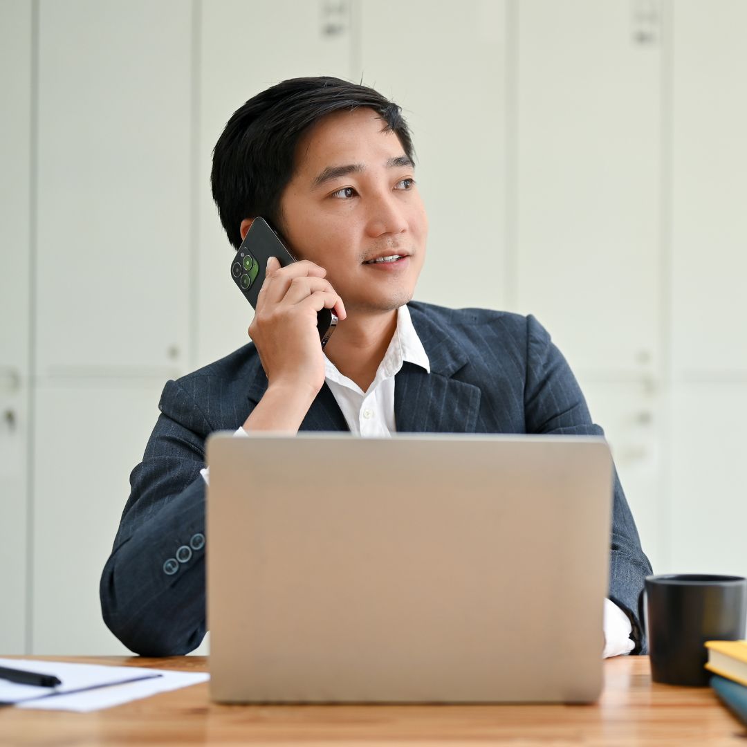 Man talking on the phone and at his laptop